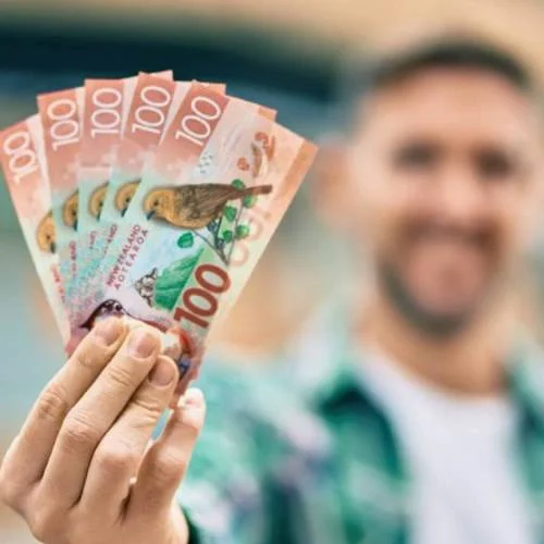 Happy customer holding cash after selling car in Palmerston North.